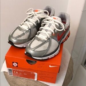 Nike WMNS AIR SPAN + 6 sneaker in metallic silver with orange accents, size 7.5